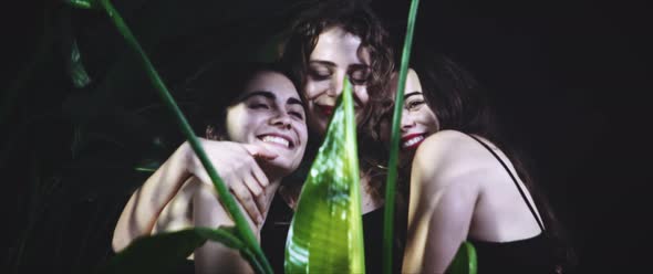 Three women hugging in the forest being happy