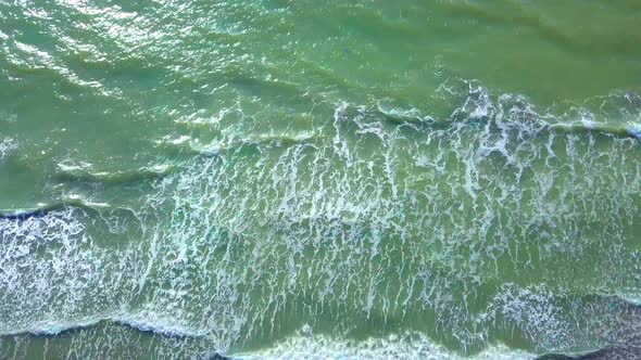 Drone view of the beautiful waves on the sandy beach,