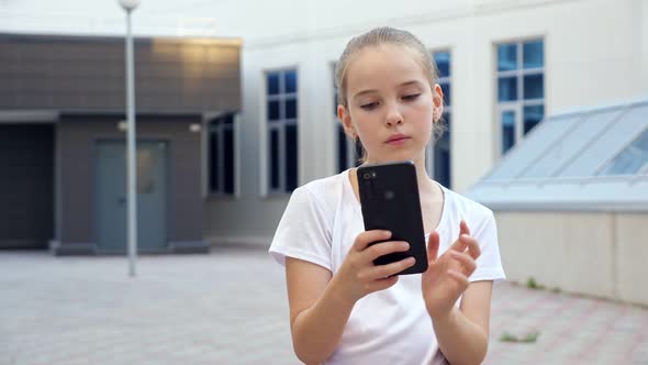 Young Blonde Teenage Girl Looks Into Display and Swipes