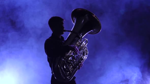 Musician in Smoky Studio Playing in Tuba, Silhouette. Slow Motion