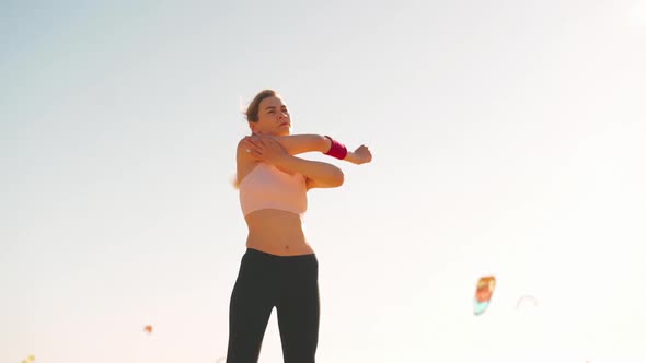 Flexible Caucasian Girl Stretches Arm After an Intensive Running Workout