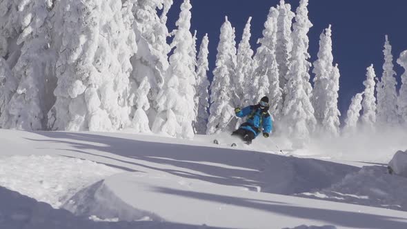 A man skiing down a snow-covered mountain in the winter.