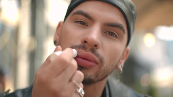 Headshot Front View of Confident Gay Man Applying Chapstick Looking at Camera