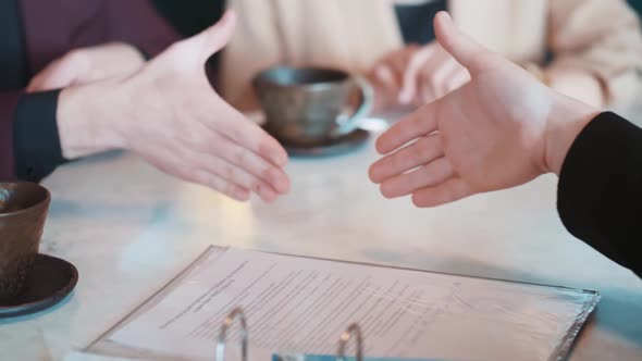 Closeup Shot of Businessperson Signing Contracts and Having Handshake with Partner After Finishing