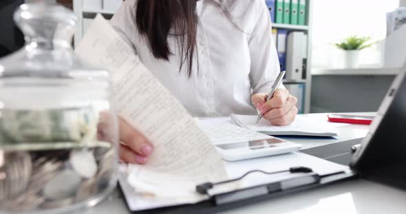 Female Accountant Looking Through Receipt While Working on Report