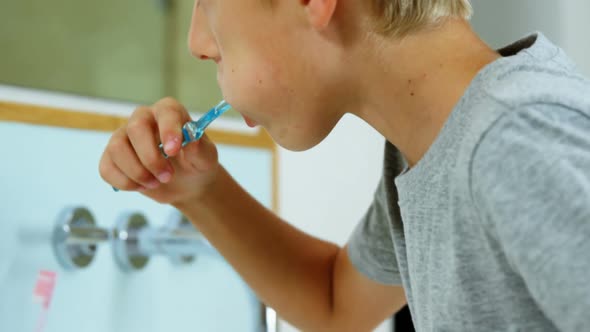 Boy brushing his teeth in bathroom