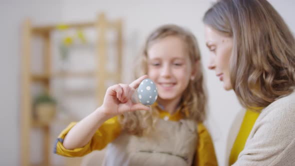 Happy Mother and Girl with Easter Egg Hugging