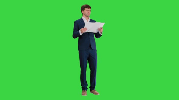 Businessman Reading Documents or Report on a Green Screen, Chroma Key.