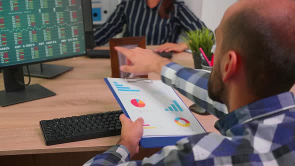 Young Employee Checking Clipboard Information