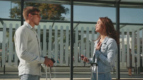 A Man and a Woman are Standing at a Public Transport Stop