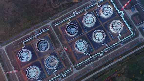 Aerial Top View of Rows of Oil Tanks Connected By Pipes at a Refinery