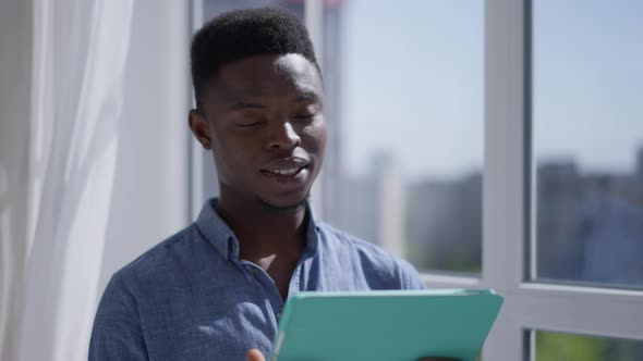 Closeup of Handsome Confident African American Man Talking at Tablet Video Chat Standing in Sunlight