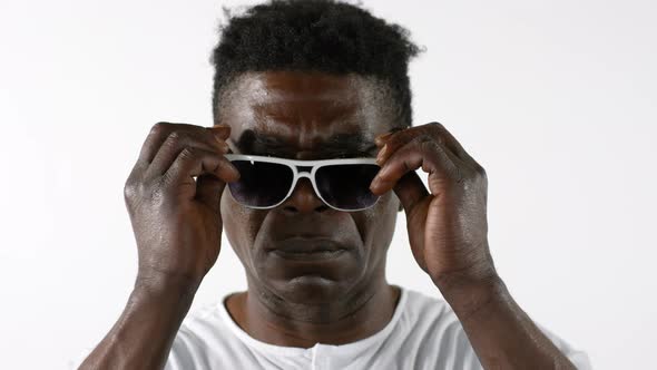 Confident African Man Putting on Sunglasses