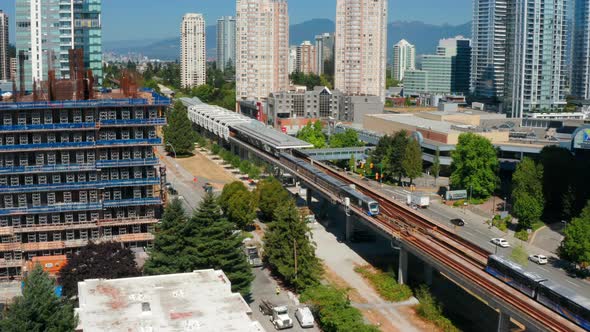 SkyTrain Departing From Metrotown Station In Burnaby, British Columbia, Canada. aerial ascend