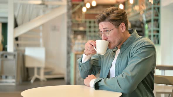 Relaxed Middle Aged Man Drinking Coffee in Cafe