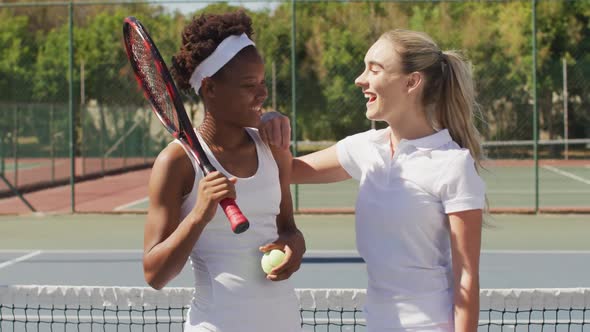 Video of happy diverse female tennis players holding rackets and talking