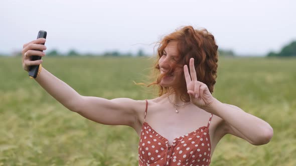 Young Beautiful Woman Doing Selfie on Mobile Phone in Sunny Day on Field