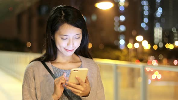 Woman using cellphone at night 