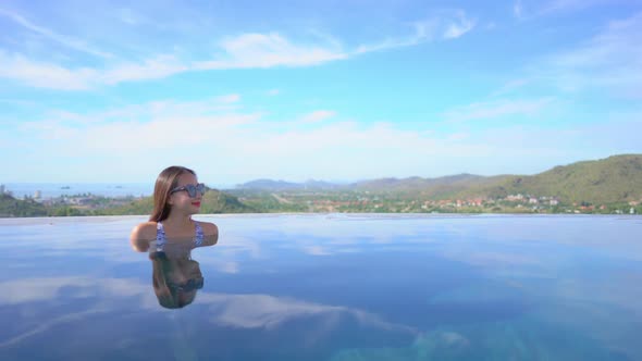 Young asian woman enjoy around outdoor swimming pool for leisure