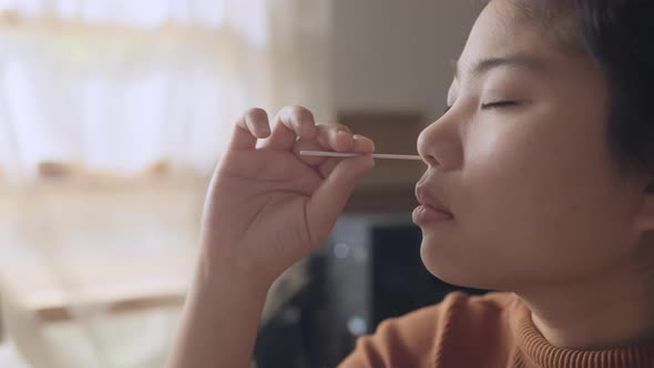 asian female hand nasal antigen swab testing rapid tests by herself for detection