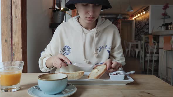 a Girl Has Breakfast in a Cafe