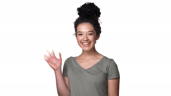 Portrait of Joyful Candid Woman with Beautiful Curly Hair in Bun Smiling on Camera and Welcoming