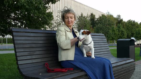 Woman Sitting in Park with Pregnant Dog