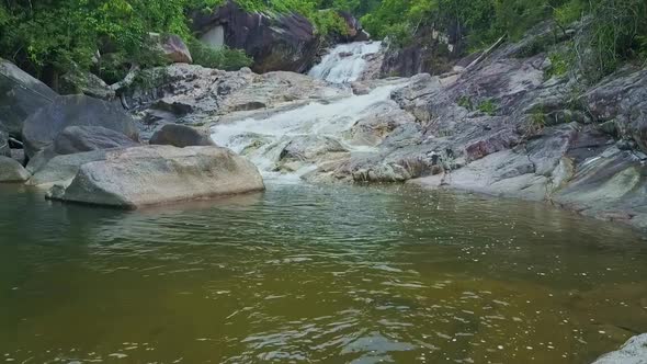 Drone Moves From Lake Up Waterfall Stream Among Rocks Jungle