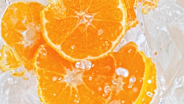 Super Slow Motion Shot of Orange Slices Falling Into Water Whirl at 1000 Fps