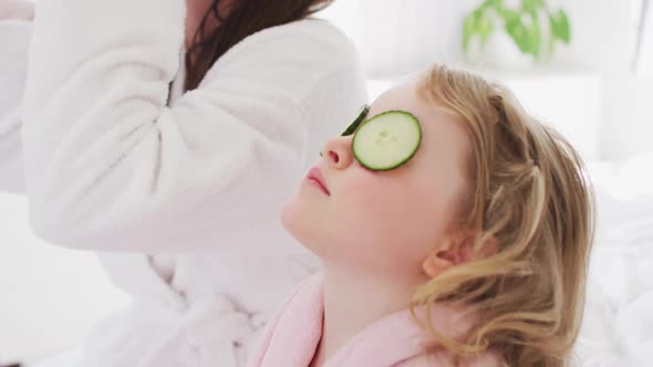 Caucasian mother and daughter having fun in bedroom