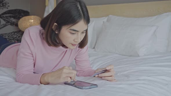 Young woman entering payment information form card in cellphone application, purchasing online.