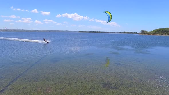 Aerial drone view of a man kiteboarding on a kite board.