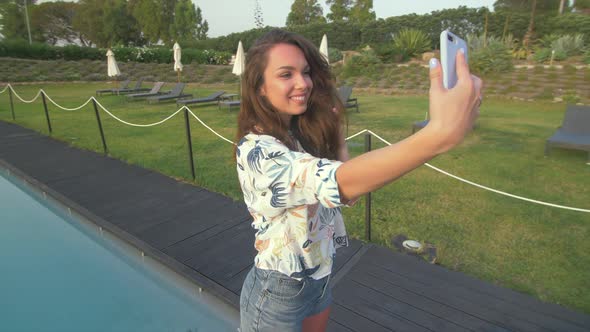 Beautiful woman making selfie mobile photo on nice luxury villa