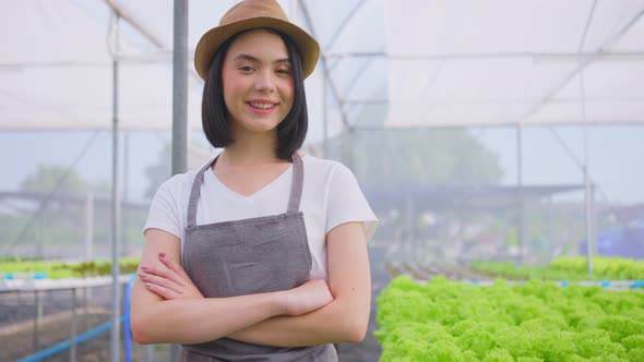 Portrait of Asian female farmer owner work in vegetables hydroponic greenhouse farm with happiness.