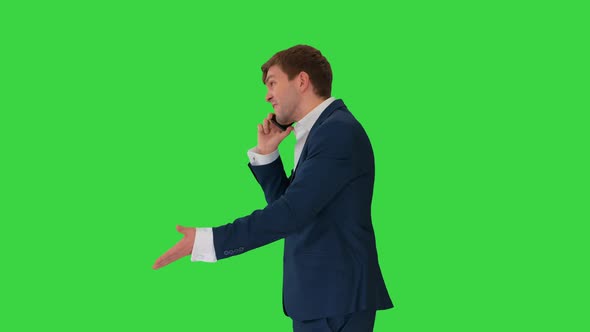 Stressed and Angry Businessman Talking on the Phone on a Green Screen, Chroma Key.