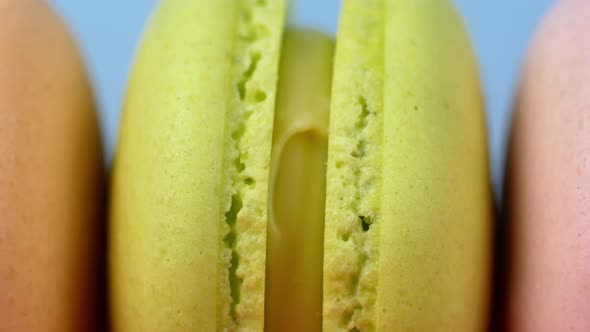 Multicolor Macarons, French macaroon, sweet tasty desserts. Isolated on a blue background