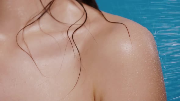 Woman Back and Shoulder Getting Water Splashes on Blue Background