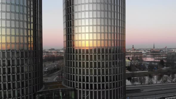 Aerial view of two glass skyscrapers on golden sunset with Riga cityscape in the background in Latvi