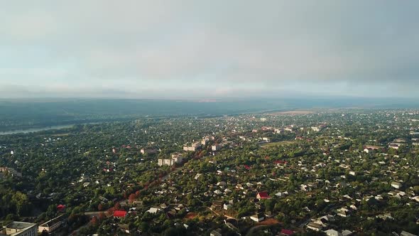 Unbelievable view of a big town nearthe river and green trees in the morning.