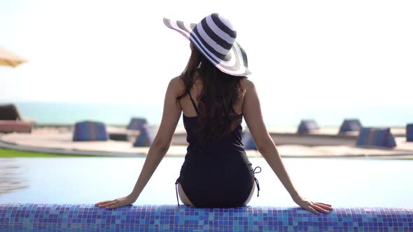 Young asian woman enjoy around outdoor swimming pool for leisure