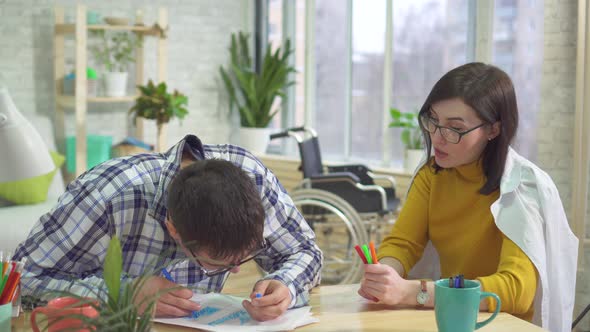 Adult Male Autistic and Doctor Learning To Draw at Home