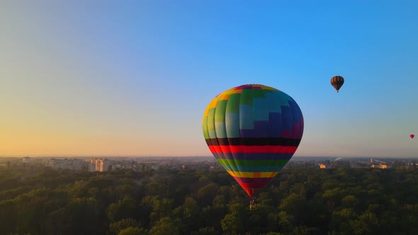 Aerial Drone HDR View of Colorful Hot Air Balloon Flying Over Green Park in Small European City at