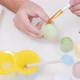 A Man Painting an Egg with Easter Eggs on a White Background Top View - VideoHive Item for Sale
