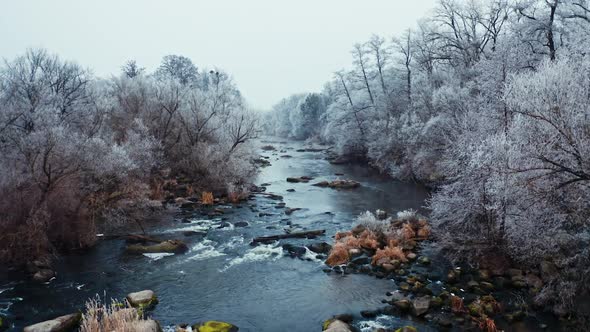 Flying over the narrow river in winter.