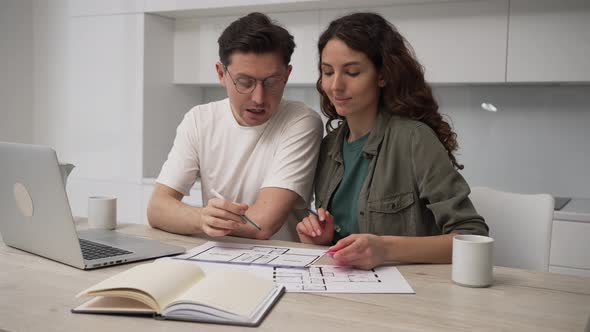 Couple Talks About Drawings of Appartment Renovation