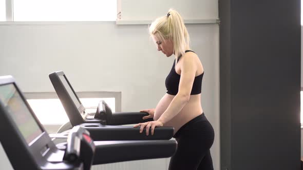 Pregnant Woman Training Treadmill Machine in Gym Cardio Exercises on Running Simulator