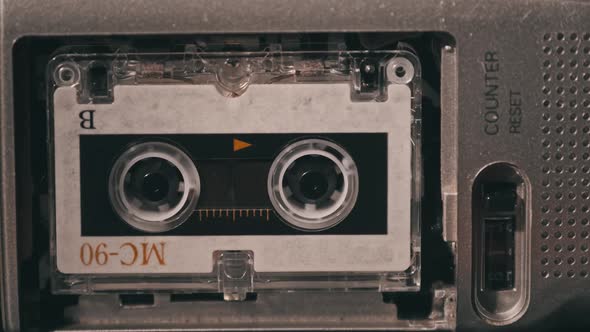 Vintage Audio Tape with a Blank Label Spinning in Cassette Recorder Closeup