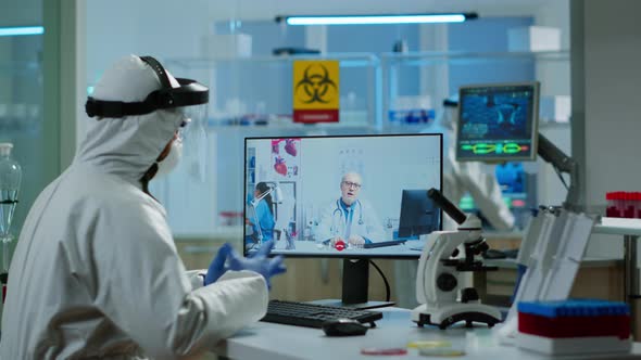 Chemist in Ppe Suit Listening Professional Doctor on Video Call