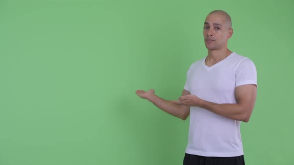 Serious Bald Man Showing To Back and Giving Thumbs Down