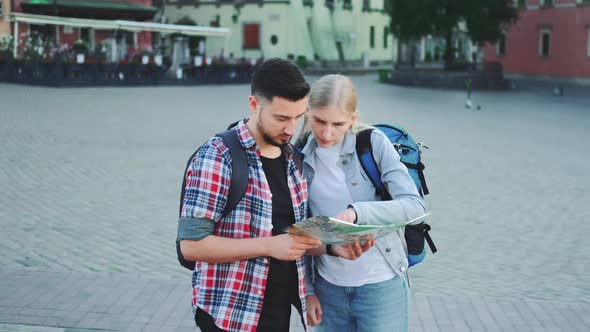 Man and Woman Holding Map and Looking for Some Place on City Square